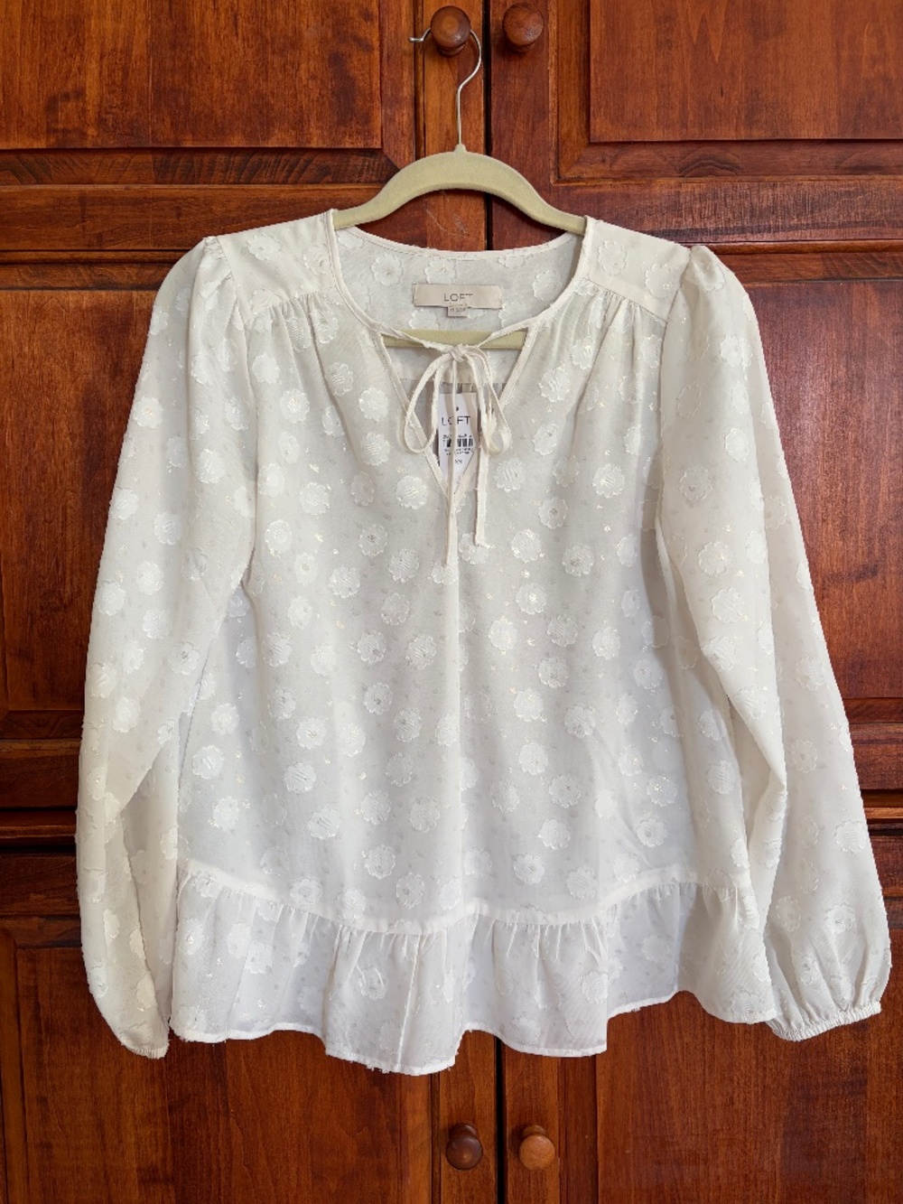 Ivory blouse with floral embossed pattern.